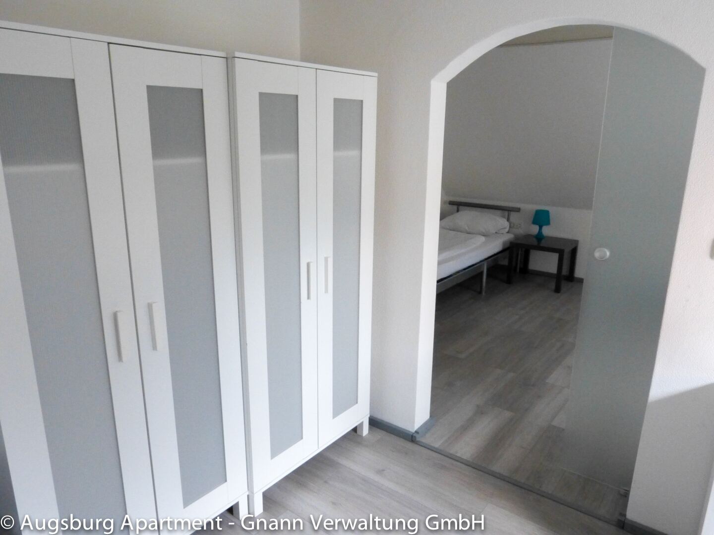 Zimmer mit zwei Kleiderschränken und Rundbogen-Durchgang zum Schlafbereich – Monteurzimmer Augsburg I