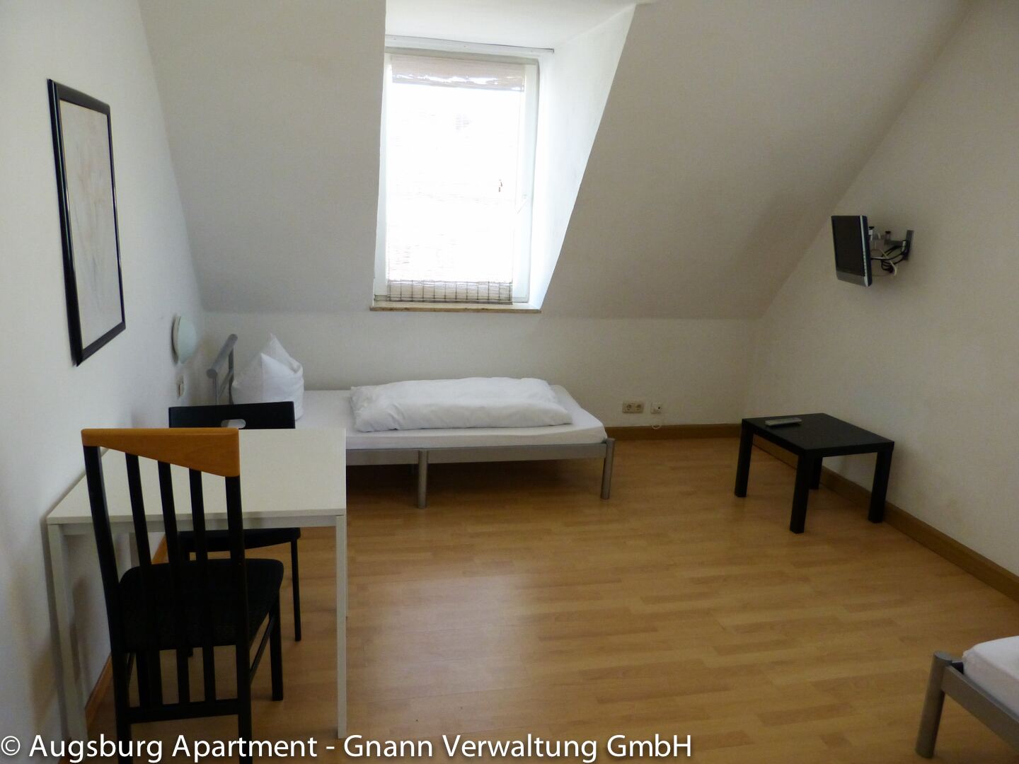 Zimmer mit Dachschräge, Schreibtisch und Wand-TV – Monteurzimmer Augsburg II